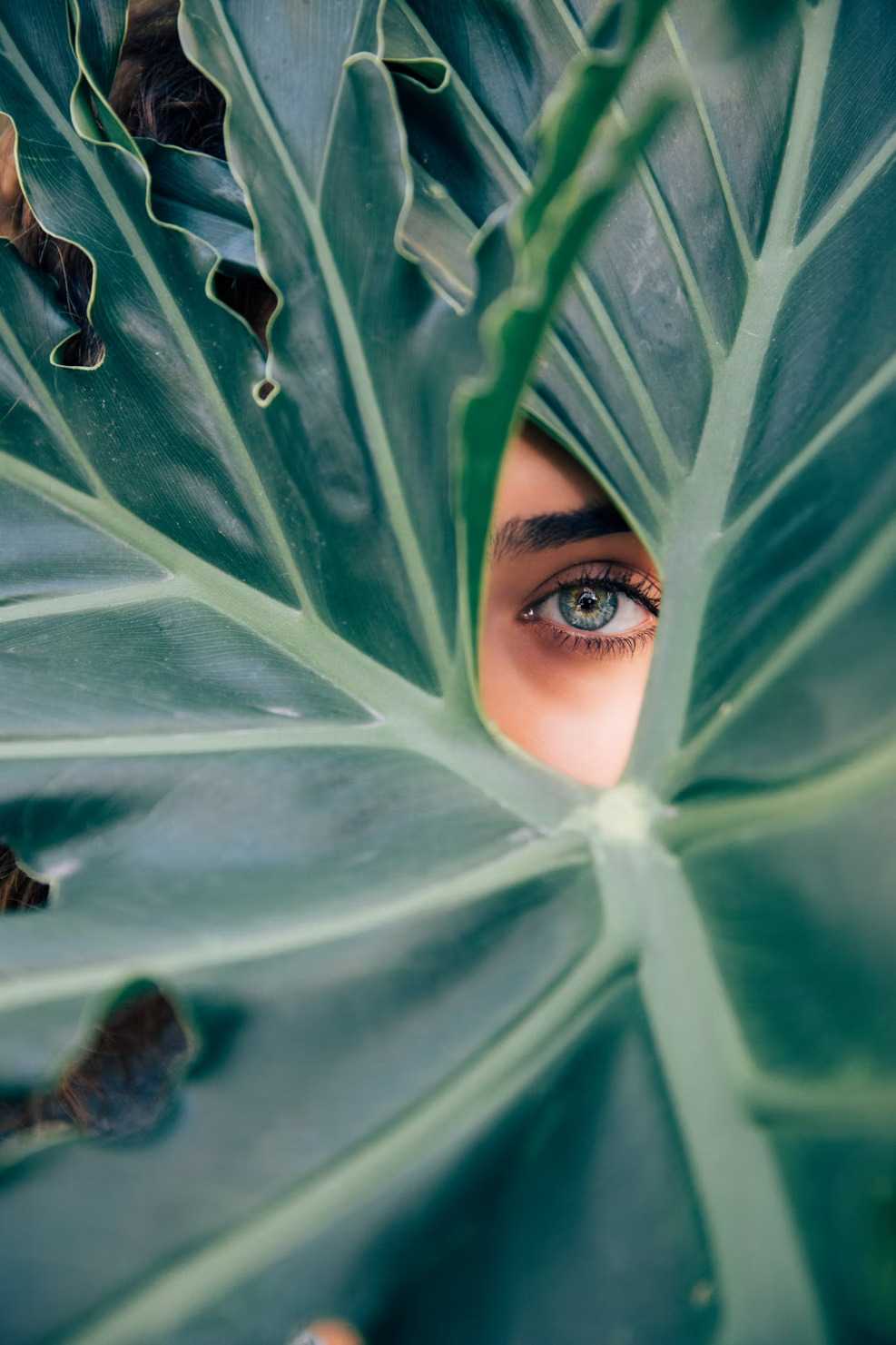 Woman behind greenery