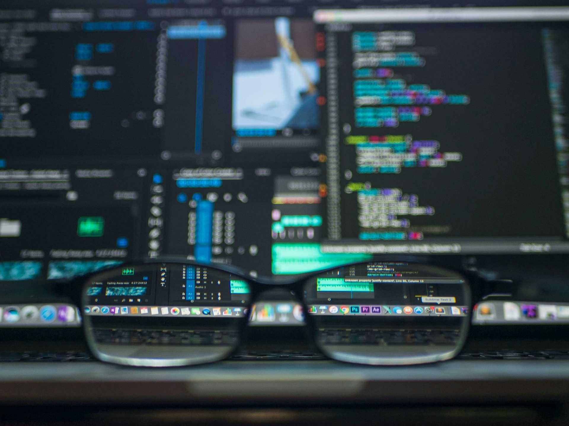 Blurred screen with glasses focusing part of it
