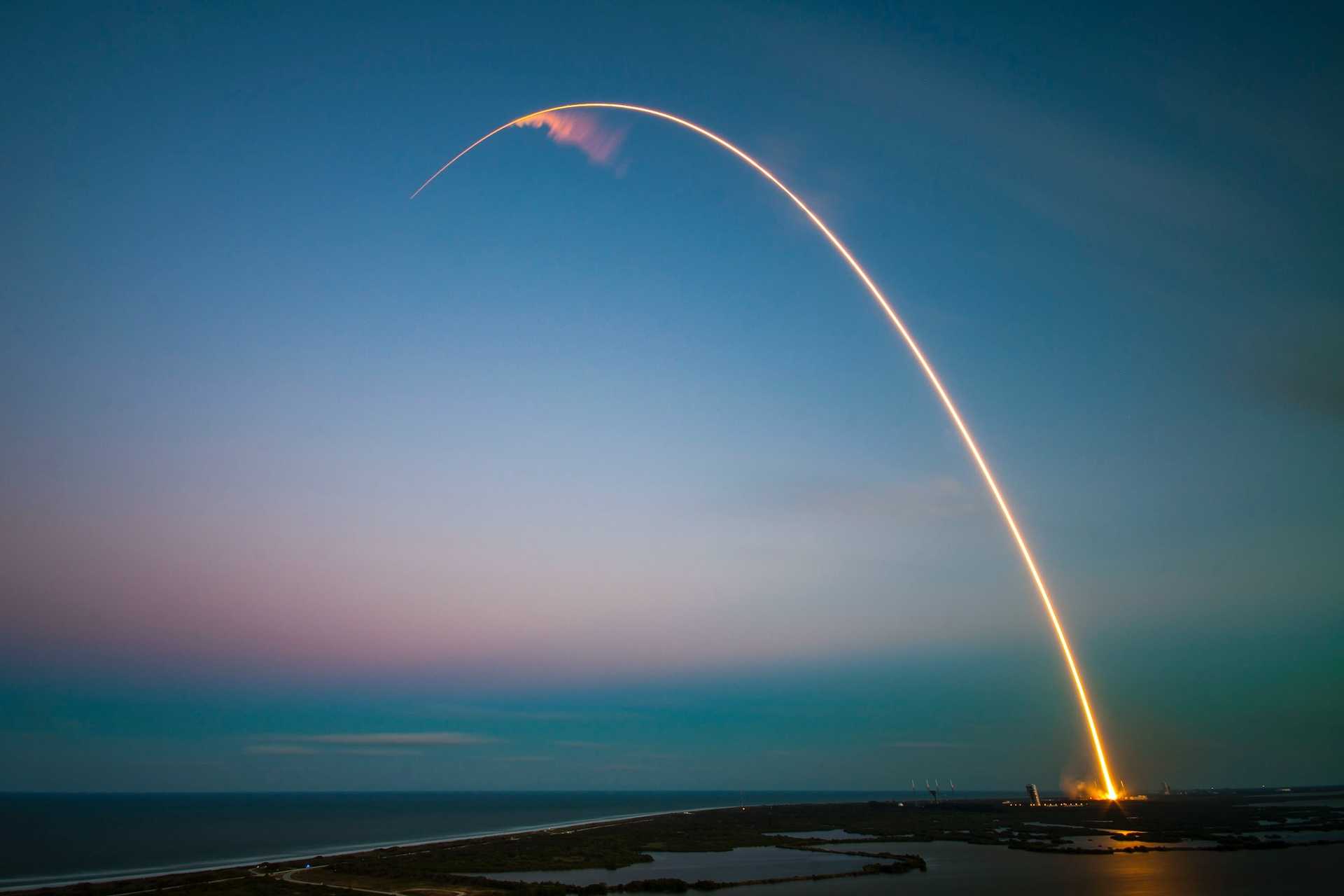 A rocket launch over the sun setting horizon